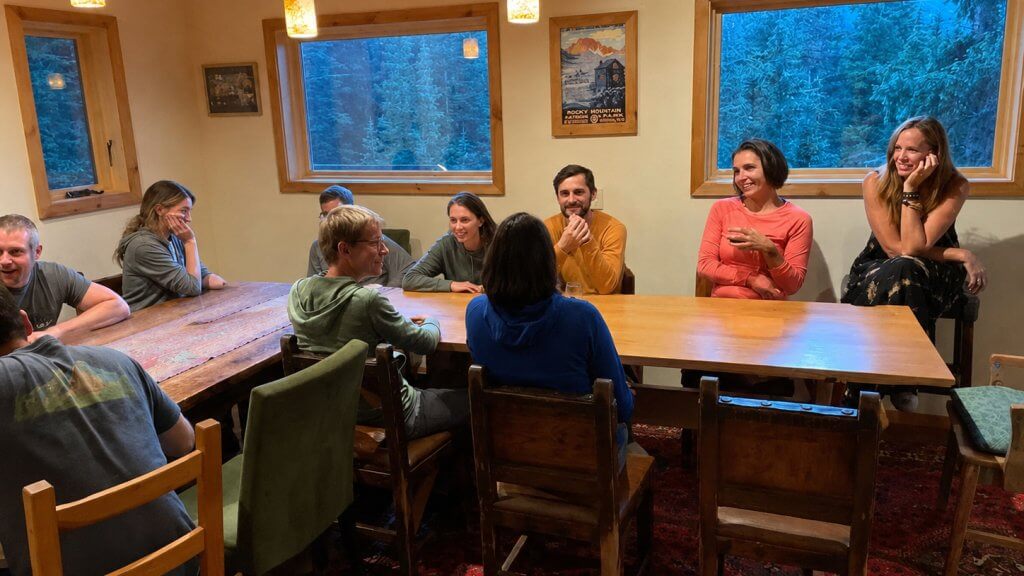 Evening conversation around a communal table at Hayden Backcountry Lodge in Colorado's San Juan Mountains.